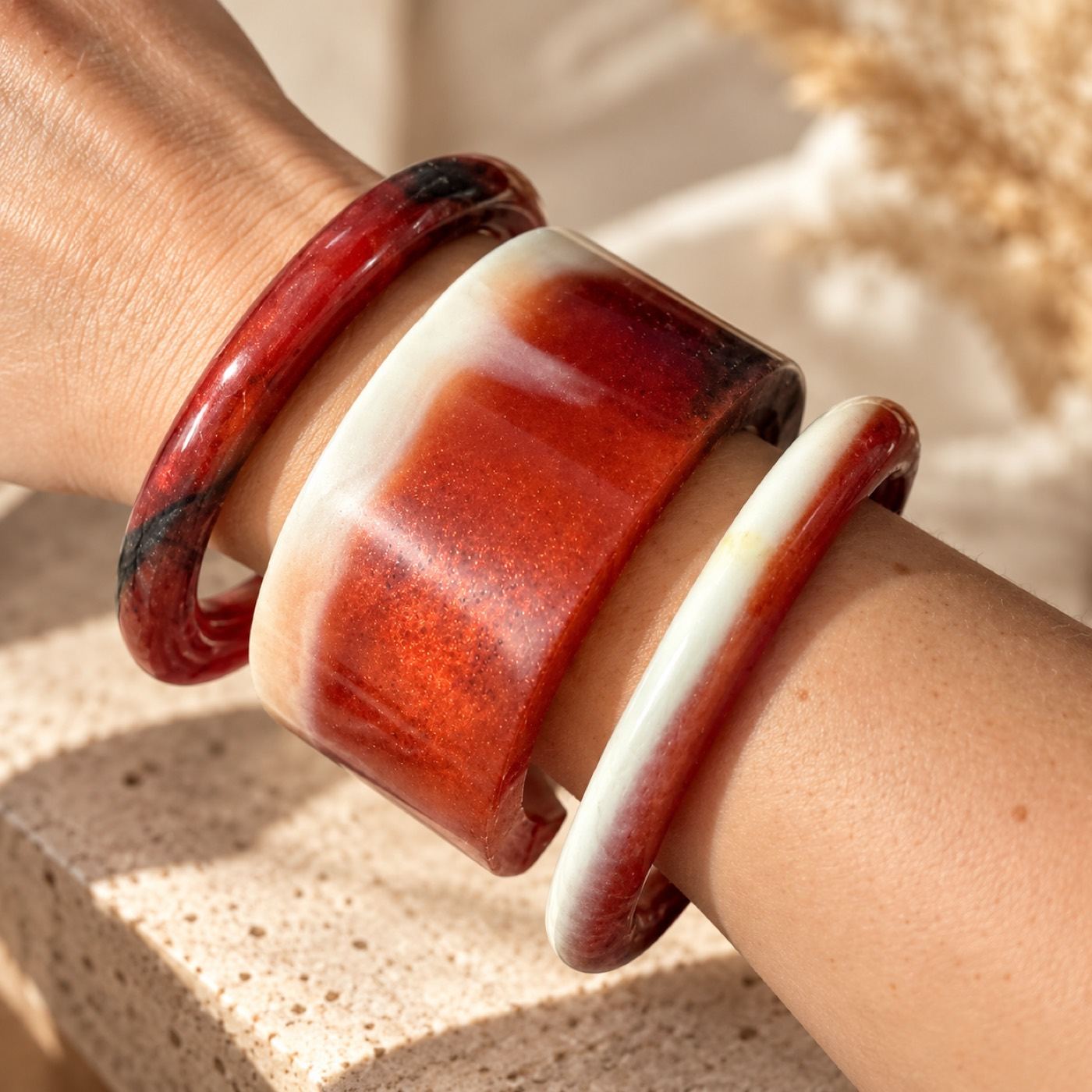 Three resin bangles worn stacked on a wrist